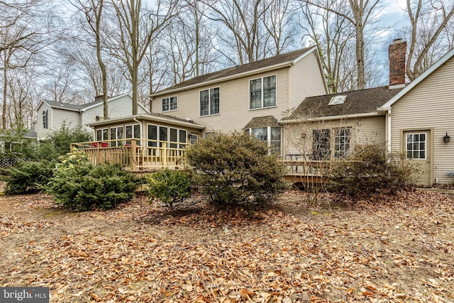 rear view of house featuring a wooden deck and a sunroom