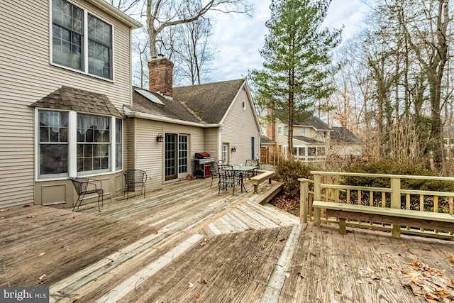 deck with outdoor dining space and grilling area