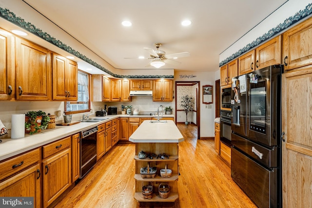 kitchen with open shelves, light countertops, light wood-style flooring, a kitchen island with sink, and under cabinet range hood