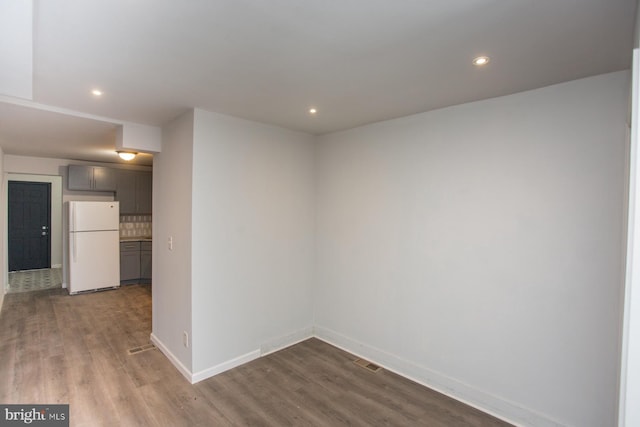 empty room featuring recessed lighting, dark wood finished floors, visible vents, and baseboards