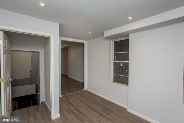 corridor with dark wood-style flooring, recessed lighting, and baseboards