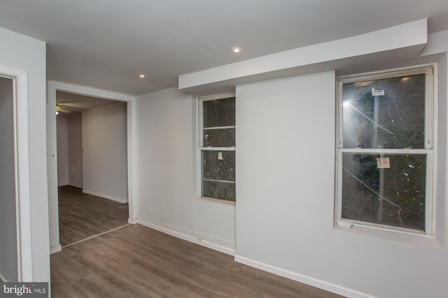 unfurnished room featuring baseboards, wood finished floors, and recessed lighting