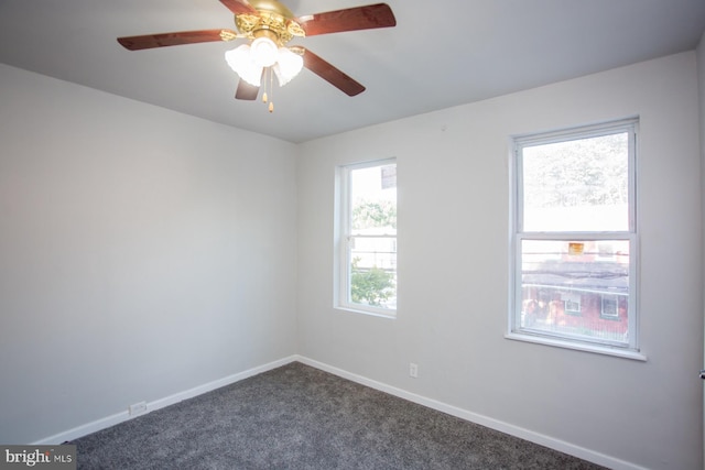 unfurnished room with ceiling fan, dark colored carpet, and baseboards