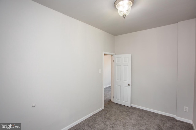 carpeted empty room with baseboards