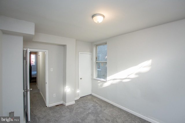 unfurnished bedroom with carpet floors, baseboards, and a closet