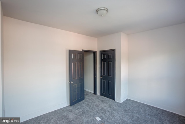 unfurnished bedroom featuring carpet floors and baseboards