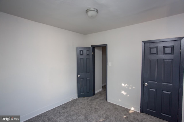 unfurnished bedroom featuring carpet flooring and baseboards