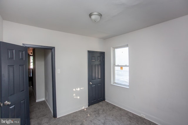 unfurnished bedroom featuring carpet and baseboards