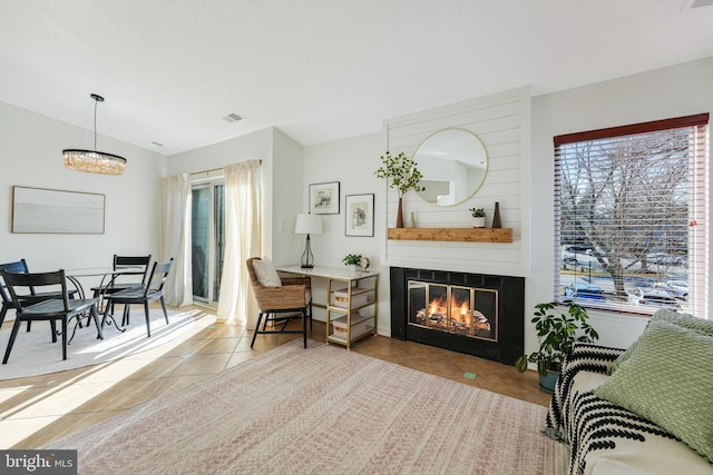 living area featuring tile patterned flooring, visible vents, and a fireplace