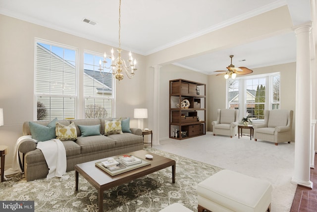 carpeted living area with ornamental molding, visible vents, ornate columns, and ceiling fan with notable chandelier