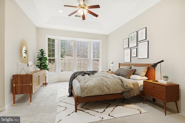 bedroom featuring recessed lighting, a raised ceiling, light colored carpet, a ceiling fan, and baseboards