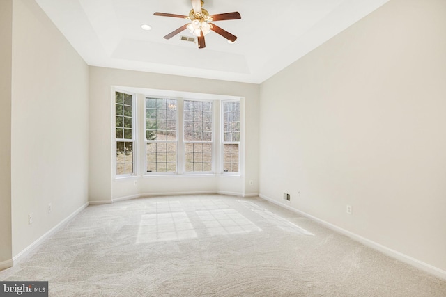 carpeted empty room featuring recessed lighting, a raised ceiling, a ceiling fan, and baseboards