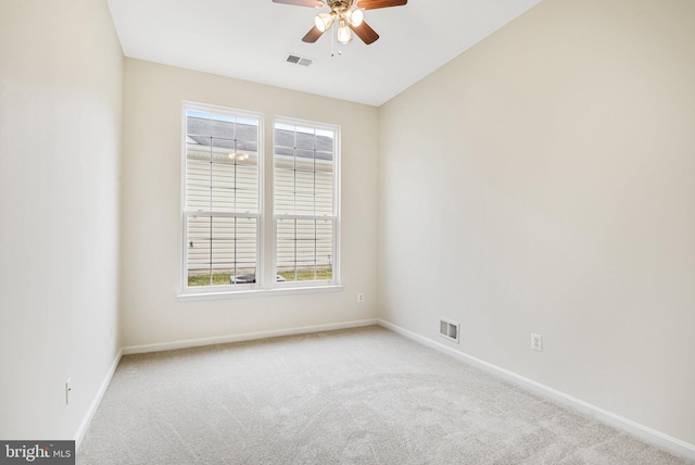 carpeted empty room featuring baseboards, visible vents, and ceiling fan