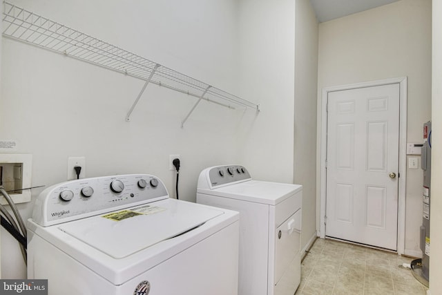 laundry room featuring laundry area, water heater, and independent washer and dryer