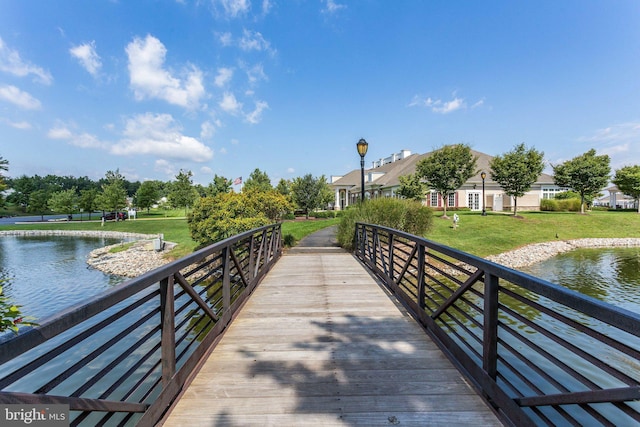 surrounding community with a water view and a yard