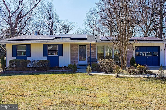 ranch-style house featuring a front lawn, brick siding, an attached garage, and solar panels