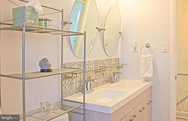 bathroom featuring a sink, backsplash, and double vanity