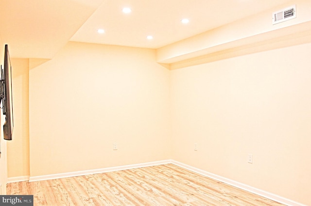 empty room featuring light wood-style floors, recessed lighting, visible vents, and baseboards