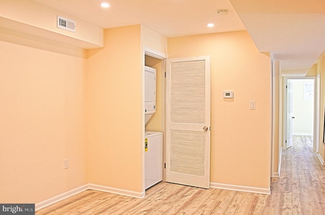 hall with recessed lighting, visible vents, baseboards, light wood-style floors, and stacked washing maching and dryer