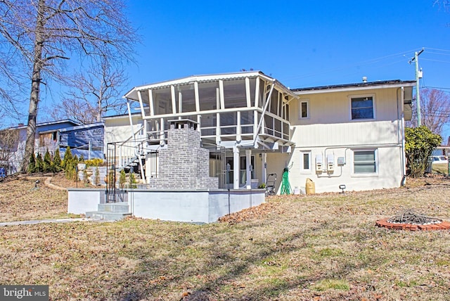 back of property with a sunroom and stairs