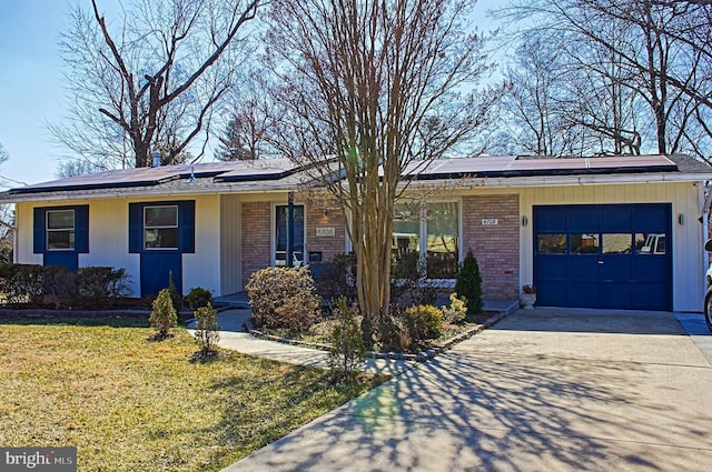 ranch-style house featuring brick siding, concrete driveway, roof mounted solar panels, a garage, and a front lawn