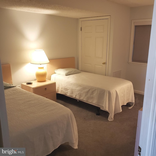 bedroom featuring dark colored carpet