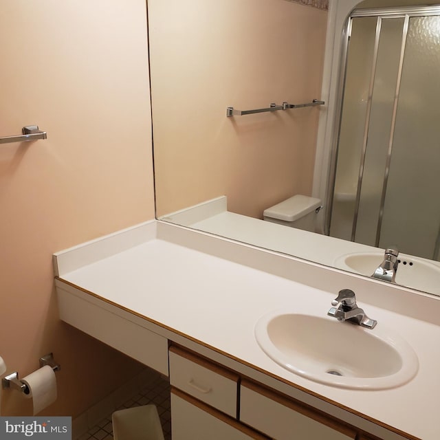 full bathroom with toilet, a stall shower, and vanity