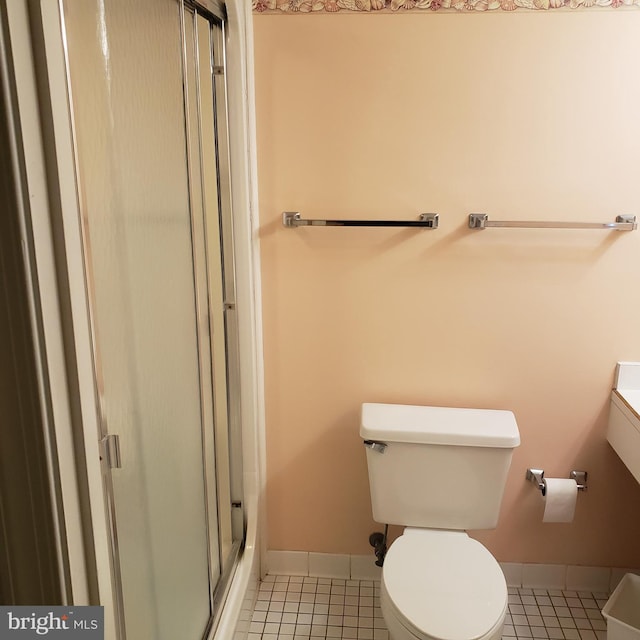 bathroom with toilet, a shower with shower door, vanity, tile patterned flooring, and baseboards