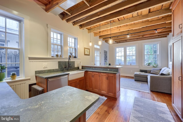 kitchen featuring radiator, beam ceiling, a sink, dishwasher, and light wood-type flooring