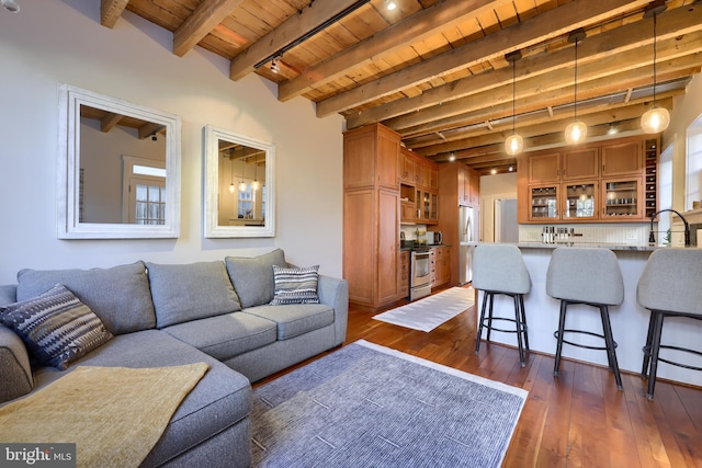 living room featuring beamed ceiling, indoor wet bar, wooden ceiling, rail lighting, and dark wood-style flooring