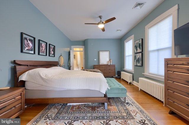 bedroom featuring visible vents, light wood-style flooring, and radiator heating unit