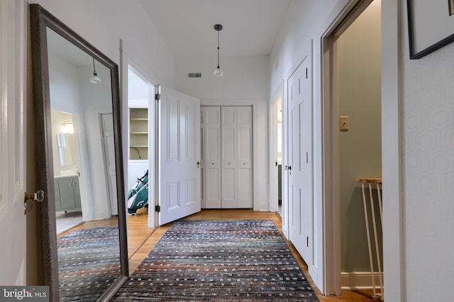 hallway featuring visible vents and light wood-style floors