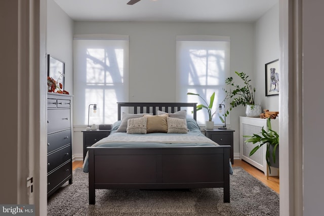 bedroom with radiator heating unit and wood finished floors