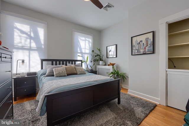 bedroom featuring visible vents, baseboards, and wood finished floors