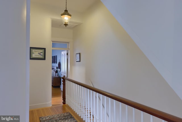 hallway featuring an upstairs landing, light wood-style floors, and baseboards