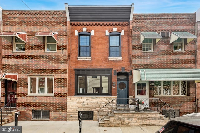 townhome / multi-family property with stone siding and brick siding