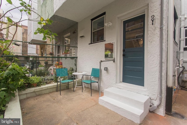 property entrance featuring fence and stucco siding