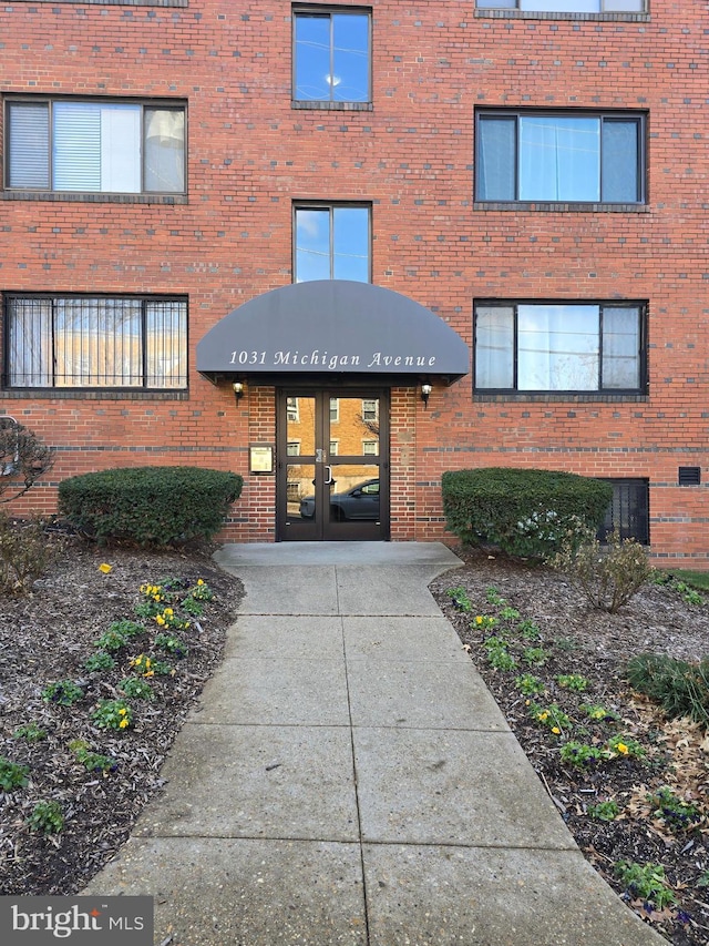 property entrance featuring french doors and brick siding