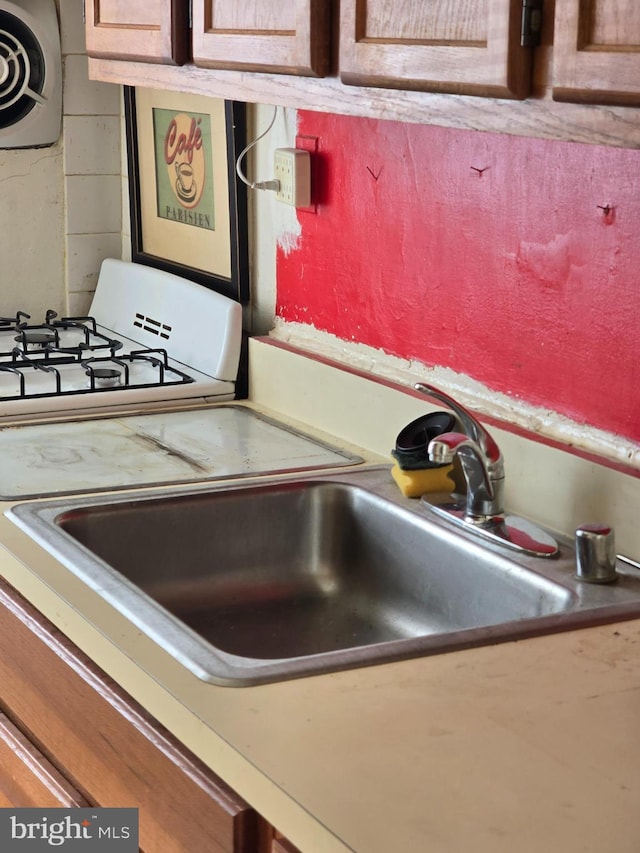 interior details featuring a sink and white gas stove