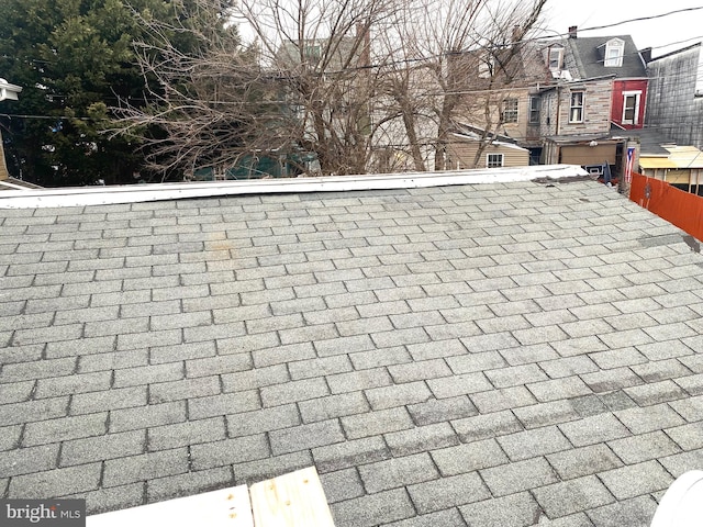 details featuring a shingled roof and fence