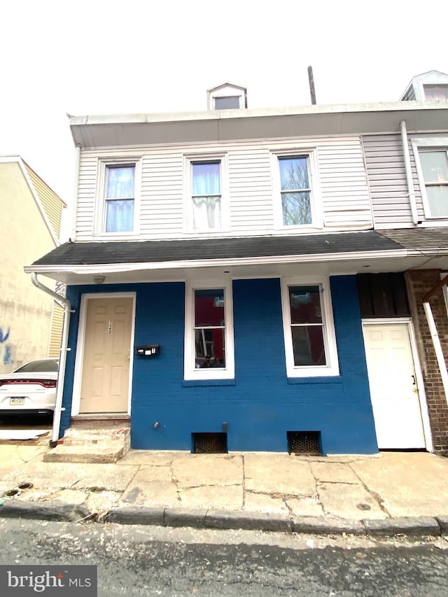 view of property with covered porch and brick siding