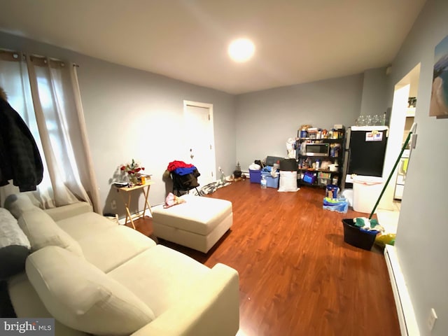 living area featuring baseboard heating and wood finished floors