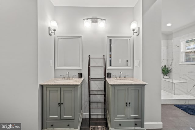 full bathroom with a tile shower, two vanities, and a sink