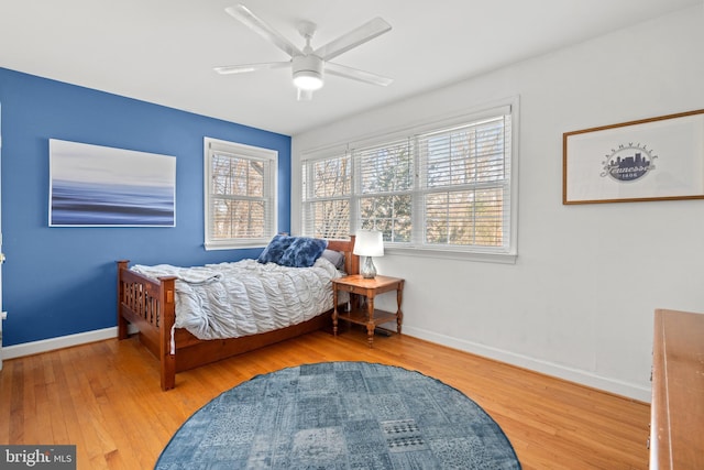 bedroom featuring ceiling fan, baseboards, and wood finished floors