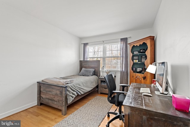 bedroom featuring wood finished floors and baseboards