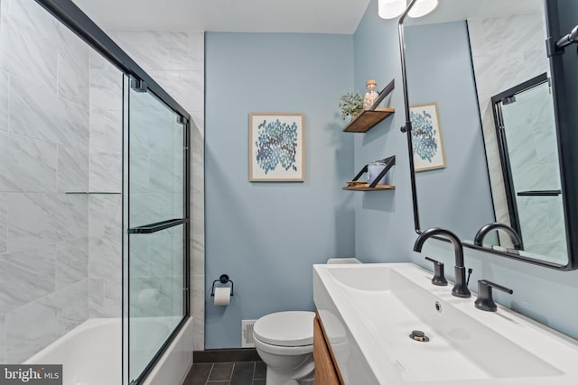 full bathroom with visible vents, toilet, enclosed tub / shower combo, vanity, and baseboards