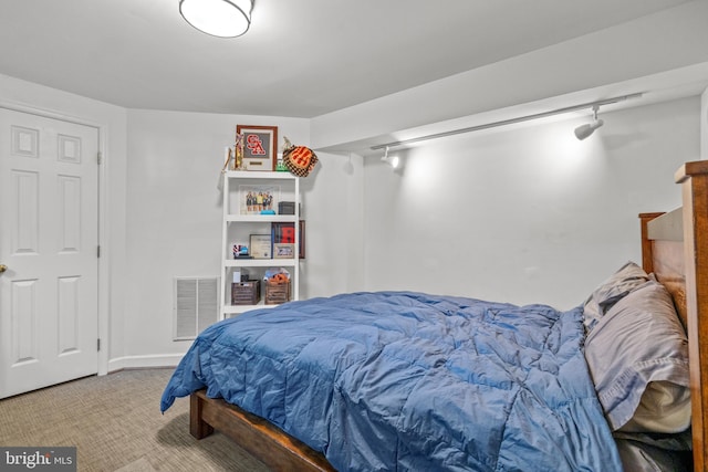 carpeted bedroom with rail lighting and visible vents