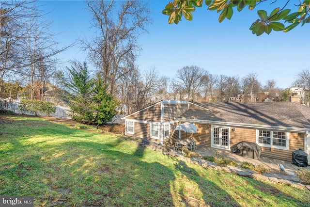 back of house featuring a yard, a chimney, fence, and a patio