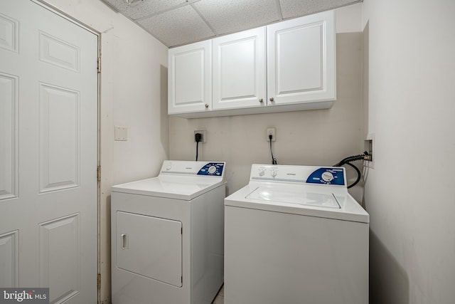 clothes washing area featuring cabinet space and washer and dryer