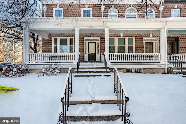 view of front of home featuring covered porch and brick siding